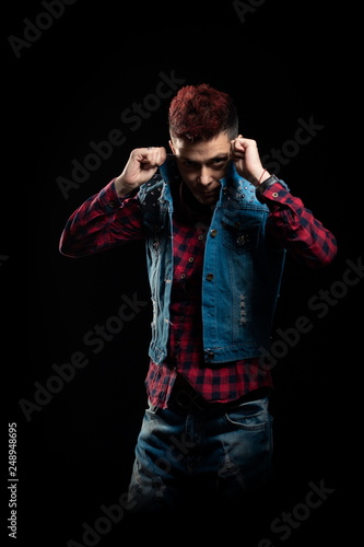 Woman with red hair in a denim suit posing on a black background photo