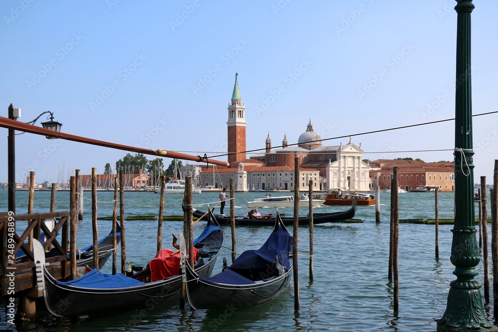 Gondolas on Riva degli Schiavoni, promenade in Venice, Italy. View of San Giorgio Maggiore church and island in the background.