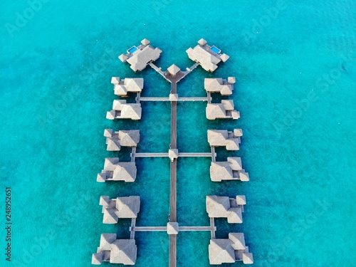 Aerial view of overwater bungalow villas with thatched roofs in the Bora Bora lagoon in French Polynesia © eqroy