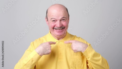 Senior happy man amazed pointing at himself in disbelief.