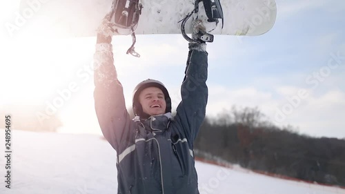 Cheering Successful Snowboarder Rising Snowboard High Above in the Air