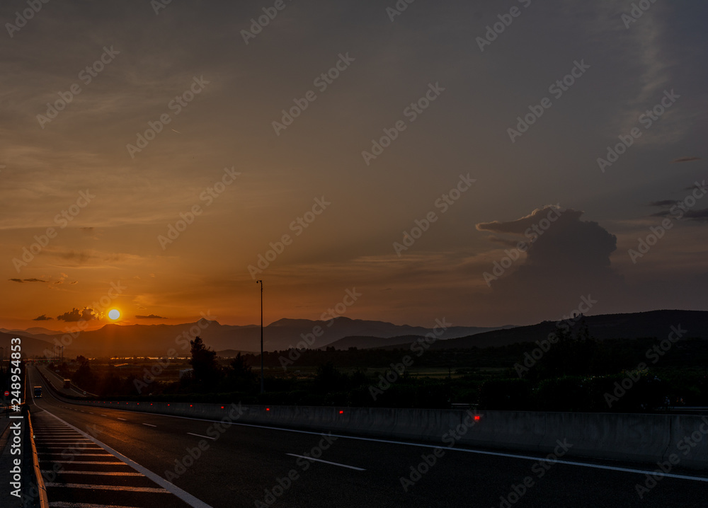 SUNSET IN A HIGHWAY AND SKY WITH CLOUDS