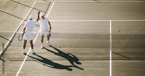 Tennis players giving a high five to each other photo