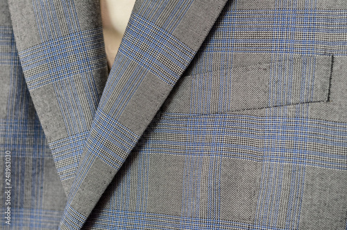 Close up of light grey and blue checked woolen jacket.
