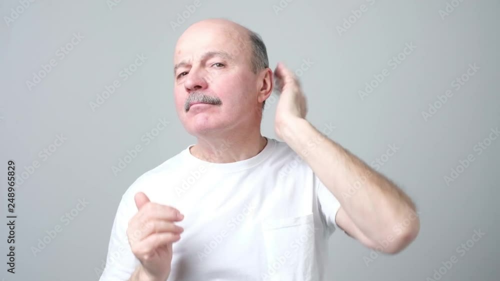 Senior bald funny man straightens hair Senior bald funny man straightens hair