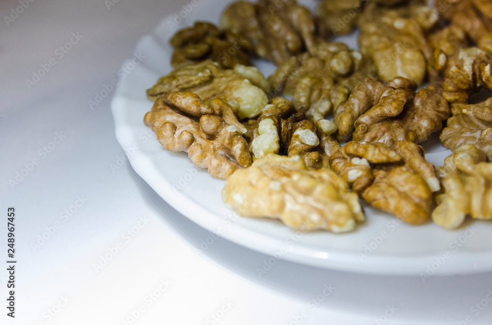 Pieces of walnuts on the white plate Pieces of walnuts on the white plate