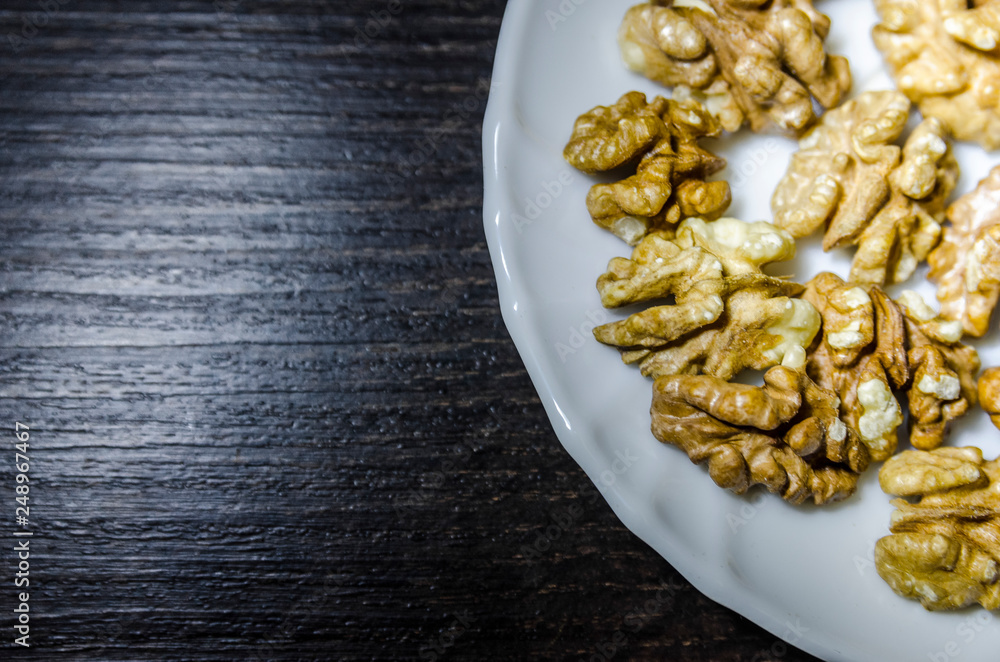 Pieces of walnuts on the white plate Pieces of walnuts on the white plate