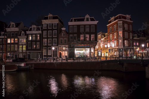 AMSTERDAM, NETHERLANDS - DECEMBER 12, 2018: view of Spiegelstraat, illuminated buildings reflected in water, Amsterdam