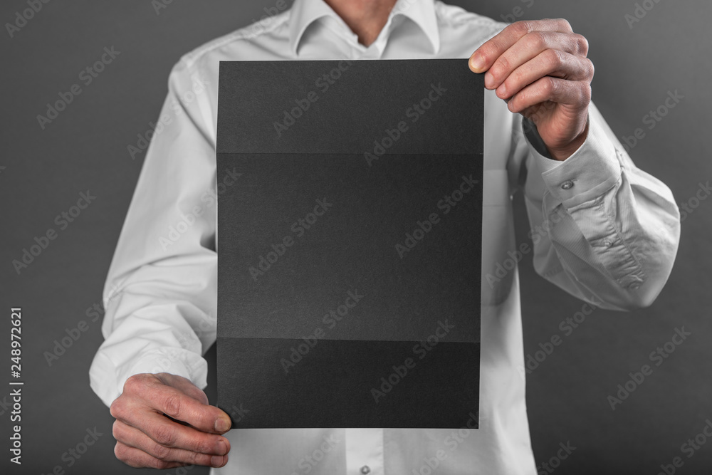 A man holding black booklet A man holding black booklet