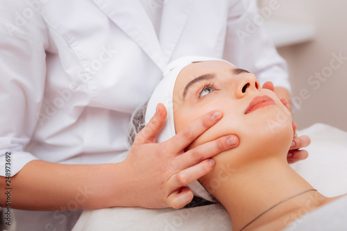 Close up of cosmetologists hand touching the clients face