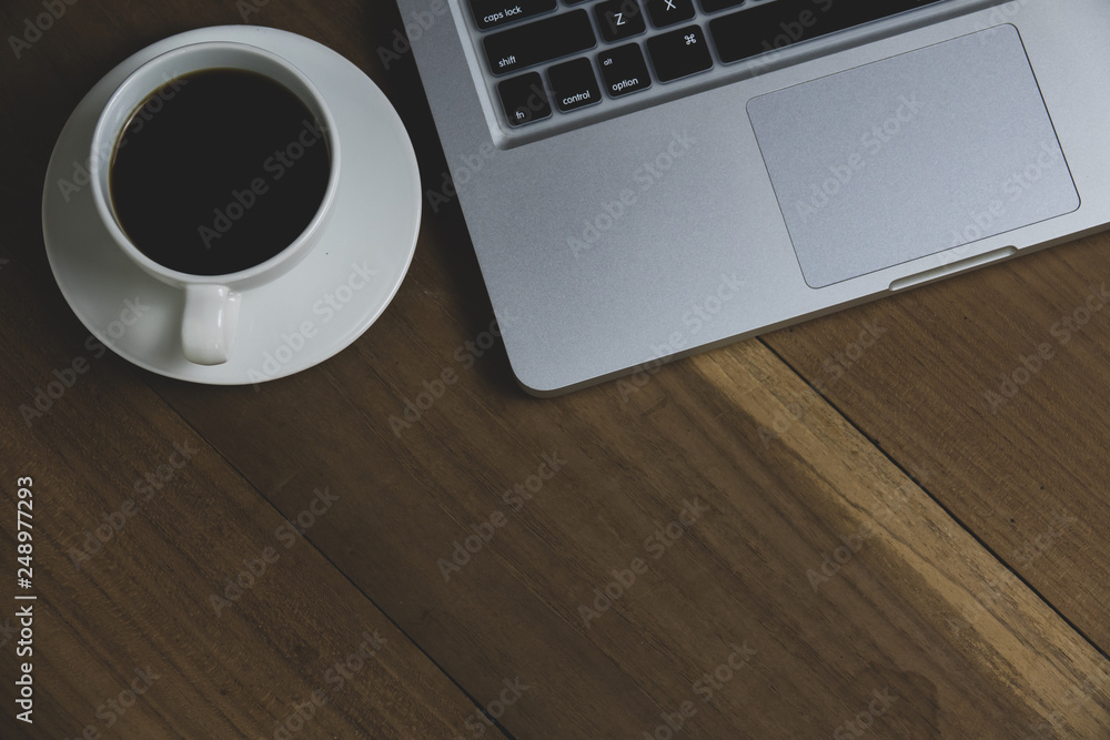 Top view table office with notebook, laptop, mobile, coffee cup, and pen with copy space on wooden table. Business concept. Top view table office with notebook, laptop, mobile, coffee cup, and pen with copy space on wooden table. Business concept.