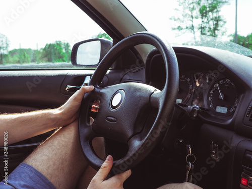 A man holding steering wheel car  wearing shorts  summer time  holiday trip
