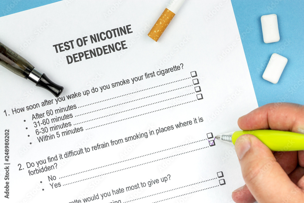 Man doing a Test of Nicotine Dependence with yellow pen Man doing a Test of Nicotine Dependence with yellow pen