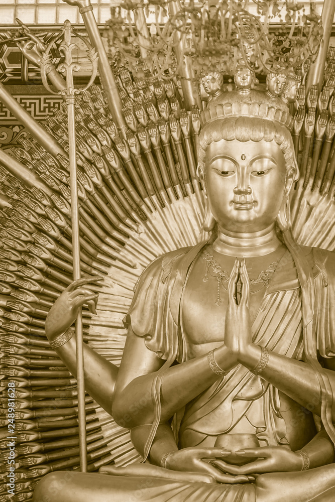 Fototapeta premium Golden statue of Guan Yin with 1000 hands. Guanyin or Guan Yin is an East Asian bodhisattva associated with compassion as venerated by Mahayana Buddhists and known as the