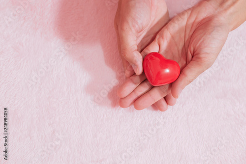 Fototapeta Naklejka Na Ścianę i Meble -  Top view hand holding red heart for valentine day concept, romantic love forever.