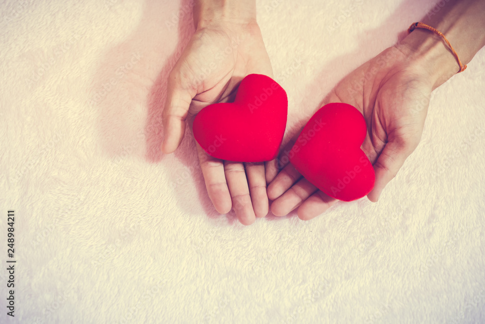 Fototapeta premium Top view hand holding red heart for valentine day concept, romantic love forever.