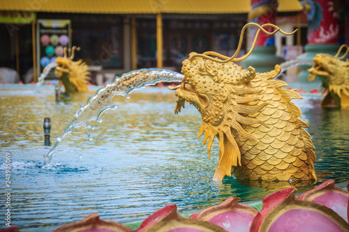 Statue of Chinese dragon fish spraying the water at the fountain in Chinese temple © kampwit