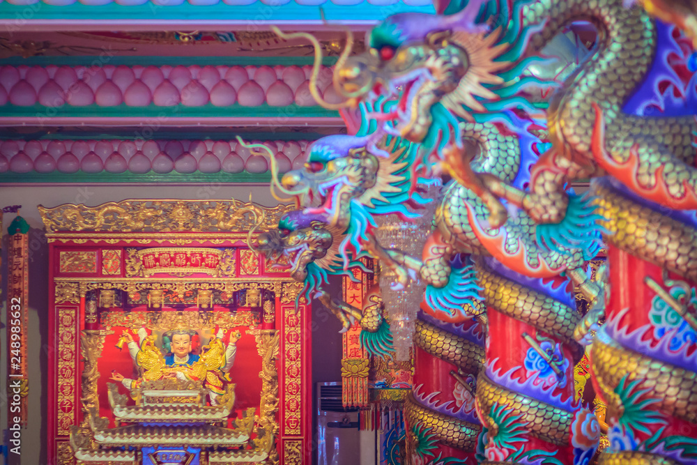 Colorful dragons and statue of Nezha, the protective deity in Chinese folk religion at Chinese public temple.