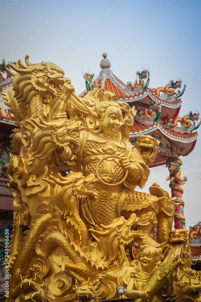 Beautiful golden Nezha statue at Wihan Thep Sathit Phra Kitti Chaloem, the famous Nezha Chinese public temple in Chonburi province, Thailand.