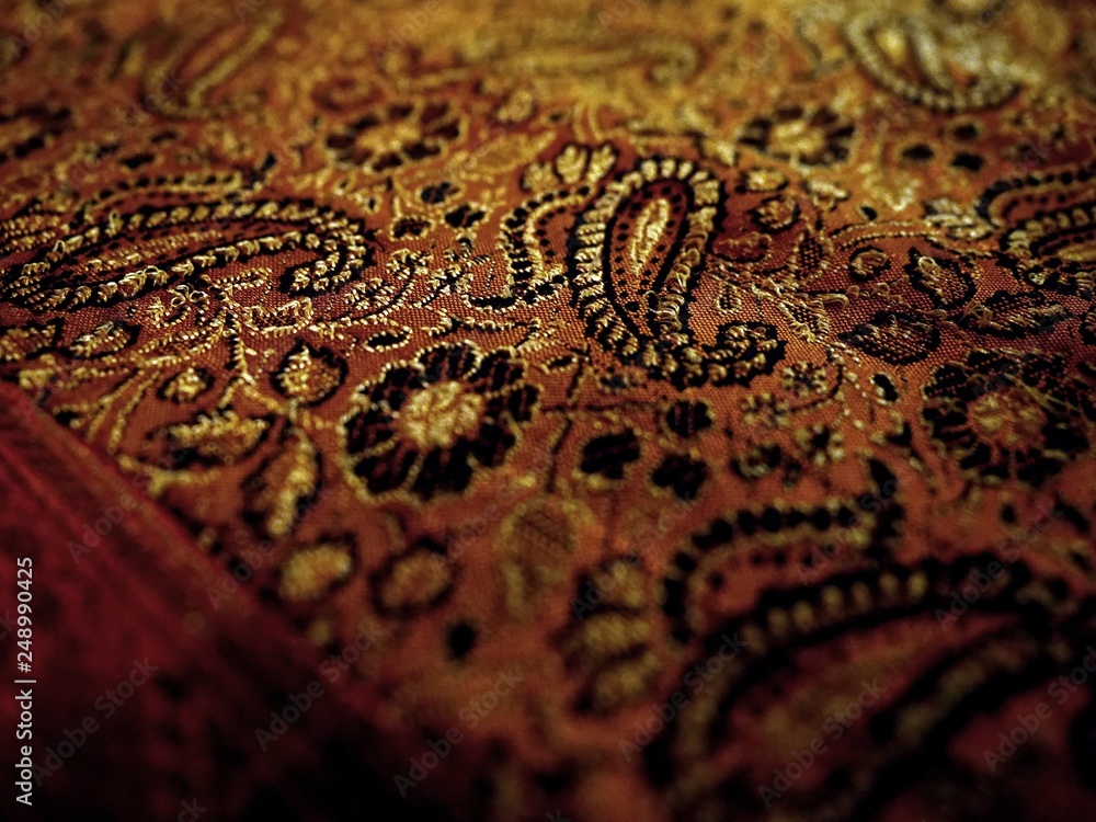 Obraz premium Gold close up detail sari beautiful fabric background, Indian ornament floral pattern with cucumbers on a natural silk cloth. Background for oriental design styles