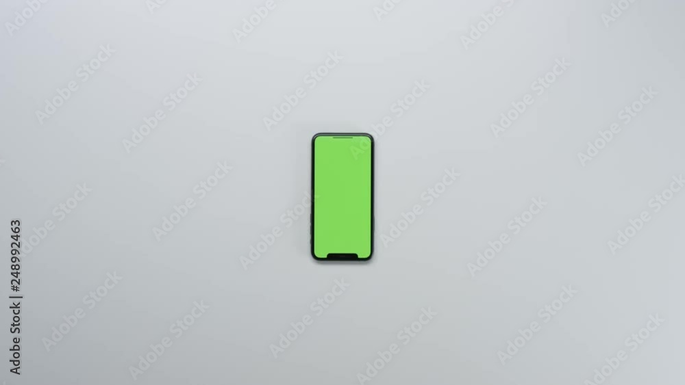 Male hands using smart device with green screen chroma on white clean minimalistic table with top view Male hands using smart device with green screen chroma on white clean minimalistic table with top view