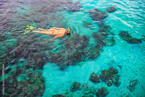 Young woman snorkeling with coral reef fishes