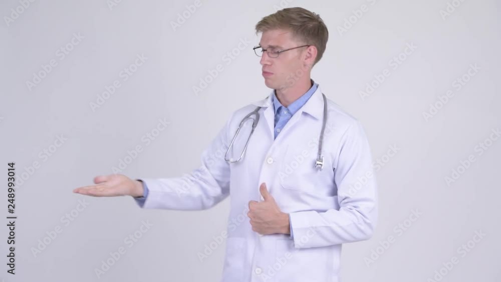 Happy young handsome man doctor presenting something Happy young handsome man doctor presenting something