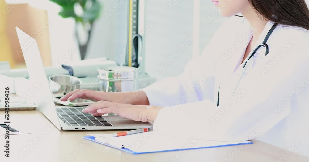 Good looking female doctor using notebook for check her patient illness history in hospital. Good looking female doctor using notebook for check her patient illness history in hospital.