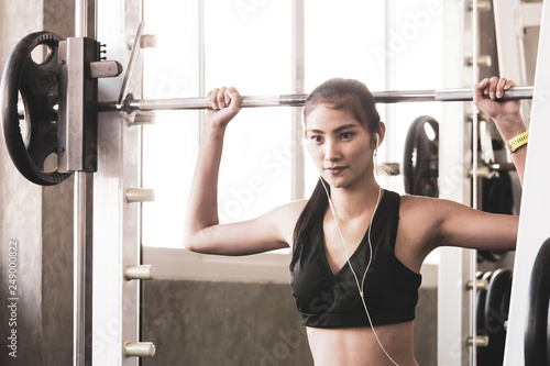 Attractive young woman exercising building muscles in a fitness gym