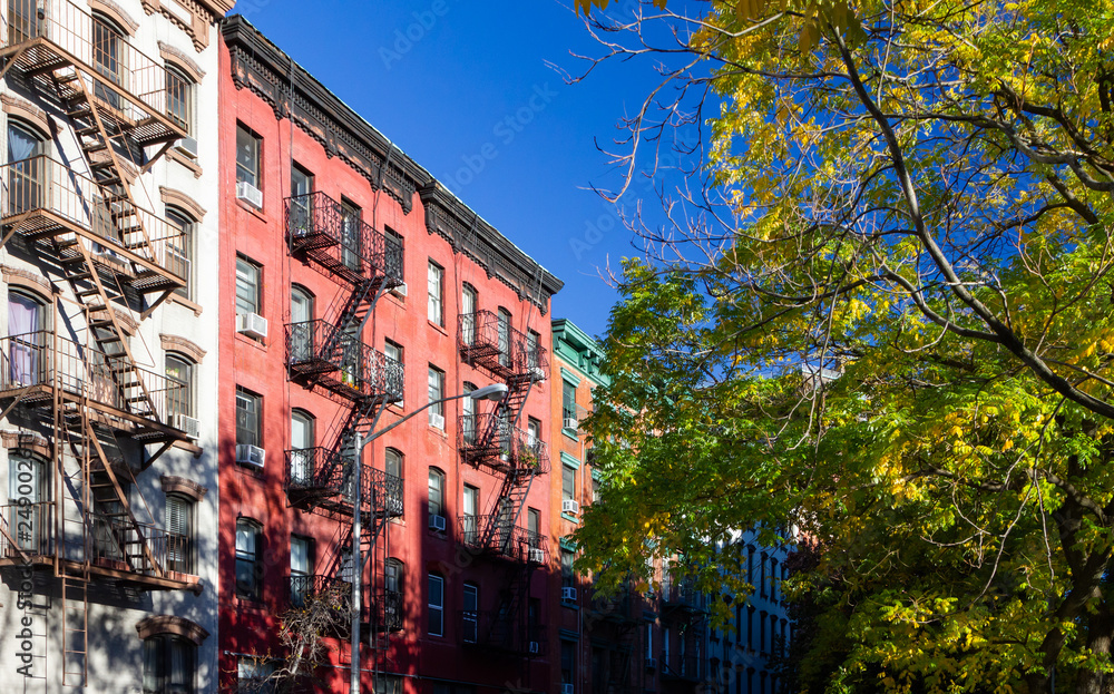 Tree lined street with old historic apartment buildings in the East Village neighborhood of New York City NYC