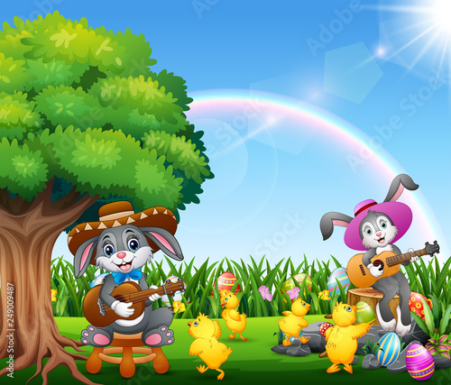 Cute bunnies relax playing guitar and surrounded by chicks