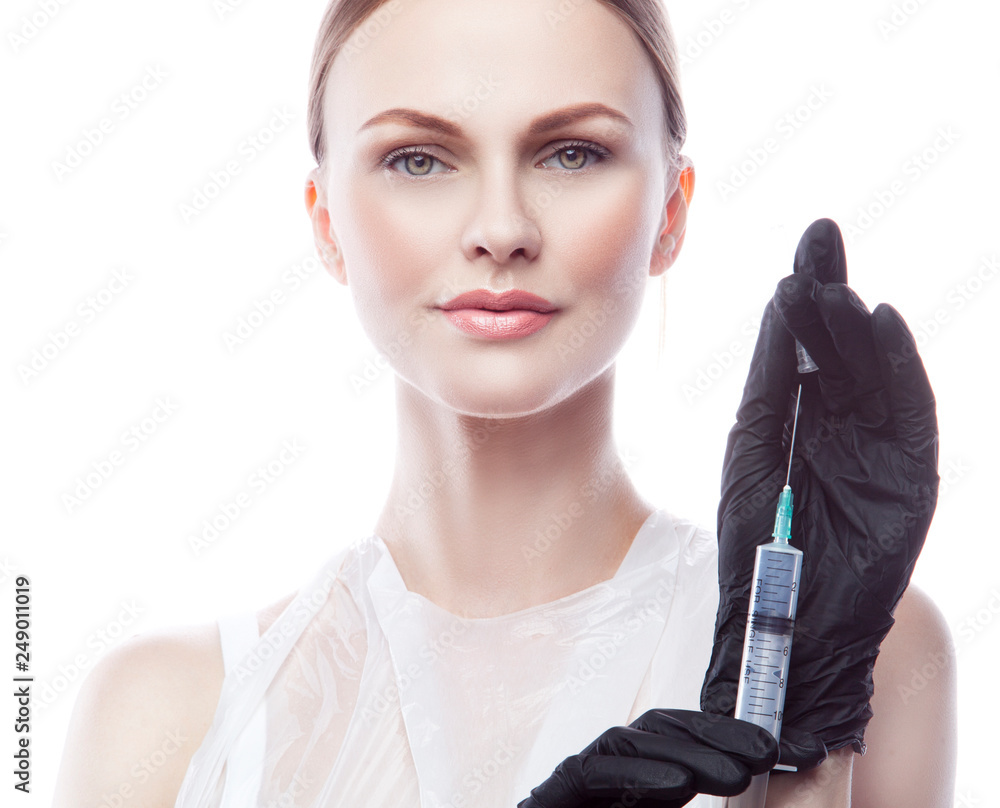Yong woman doctor beauty portrait with syringe in hands. Isolated. White background. Yong woman doctor beauty portrait with syringe in hands. Isolated. White background.