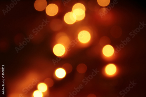 abstract blurred glowing light particles of shades of light gold and red © sharan