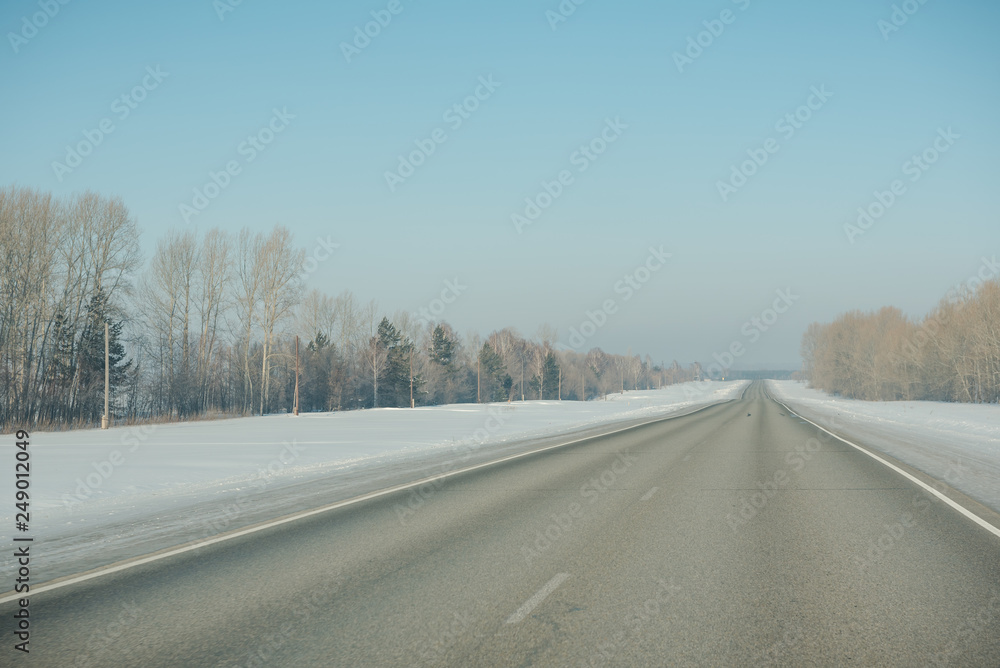 The road in winter. Asphalt road in winter. Road under the snow.