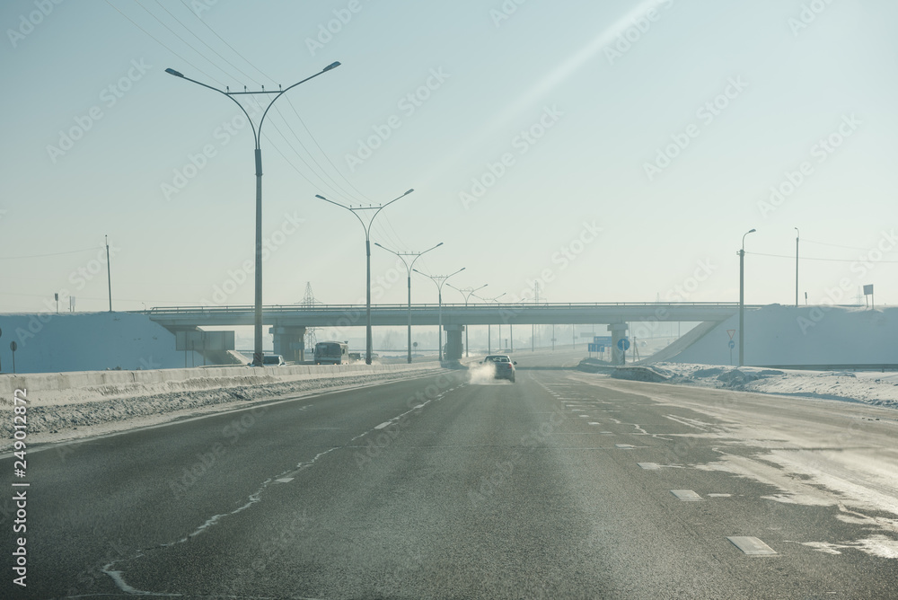 Fototapeta premium The road in winter. Asphalt road in winter. Road under the snow.