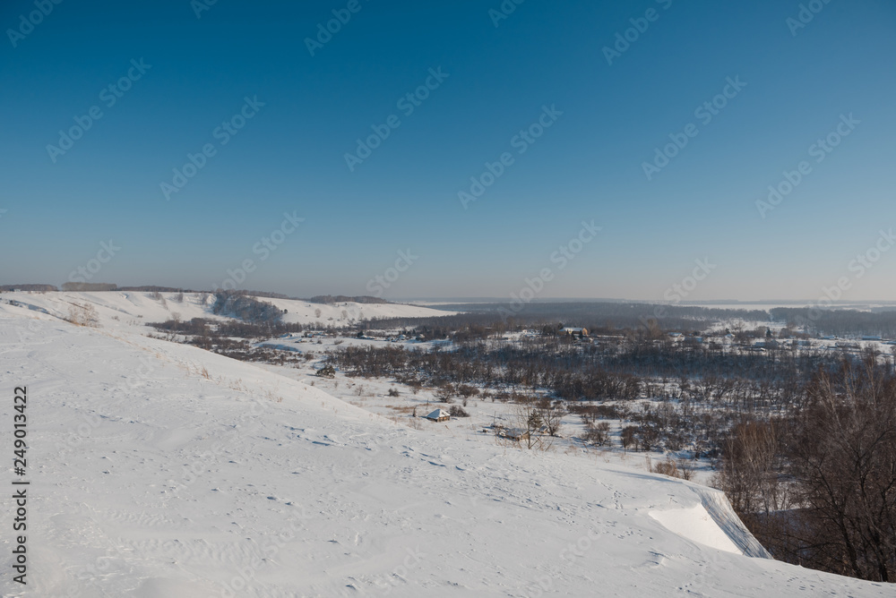 Winter view of the village from above. Houses in the snow. Countryside under the snow.