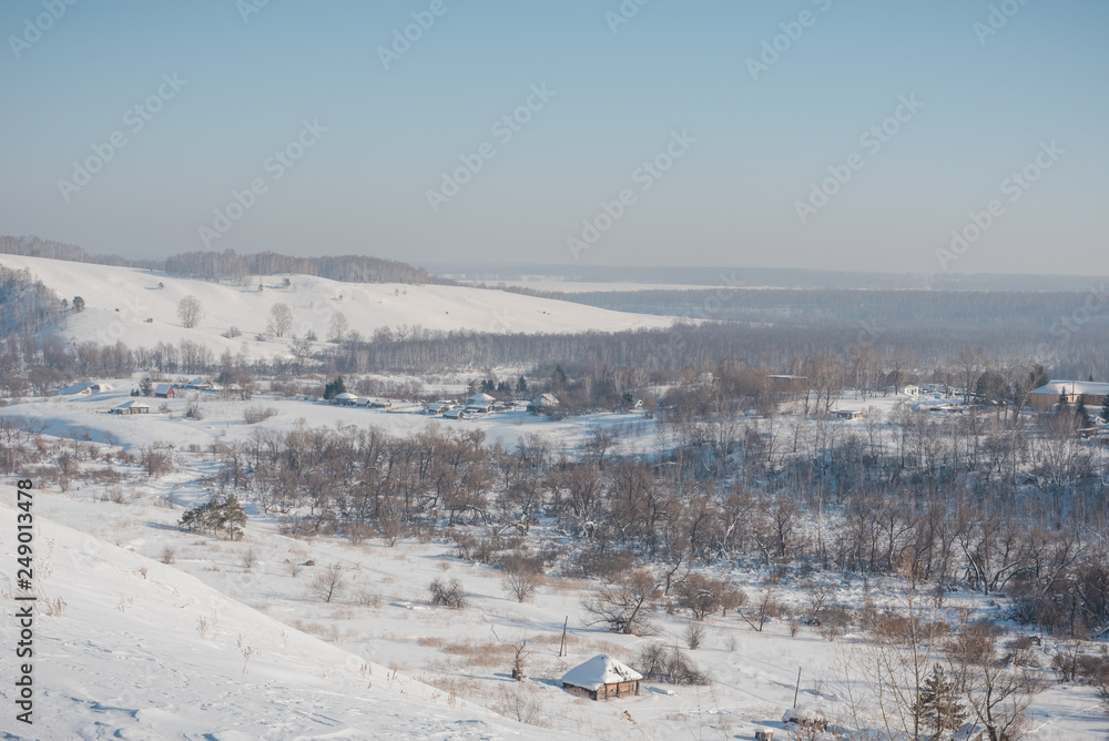 Winter view of the village from above. Houses in the snow. Countryside under the snow.