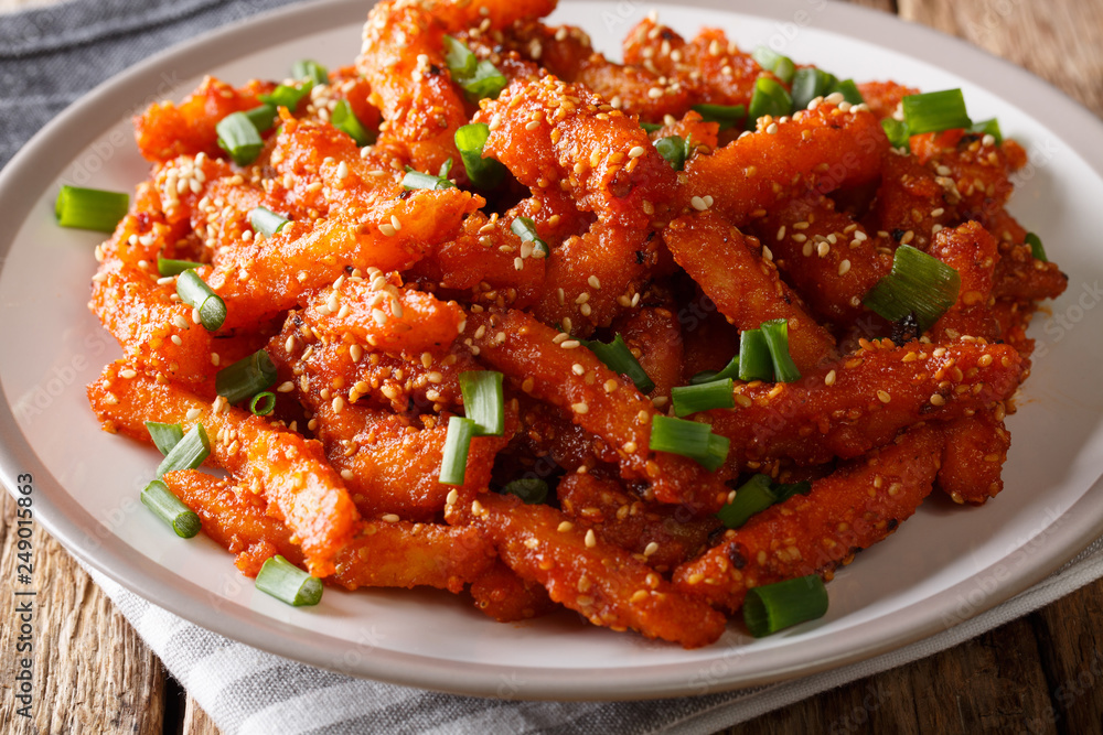 Delicious honey chilli potatoes with spicy sweet sauce and green onions close-up. horizontal Delicious honey chilli potatoes with spicy sweet sauce and green onions close-up. horizontal