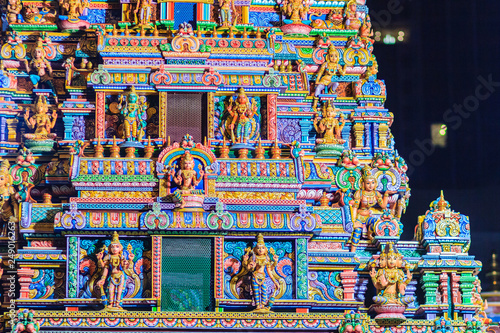 Colorful night view of indian gods sculpture at Sri Maha Mariamman Temple, also known as Maha Uma Devi temple, the public hindu temple in Silom, Bangkok, Thailand. It known as Wat Khaek Silom. photo