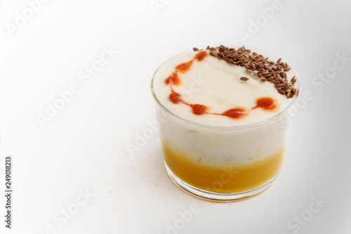 lobster bisque soup with a creamy foam topping and linen seed garnish in a glass on a light gray table, copy space, selected focus,