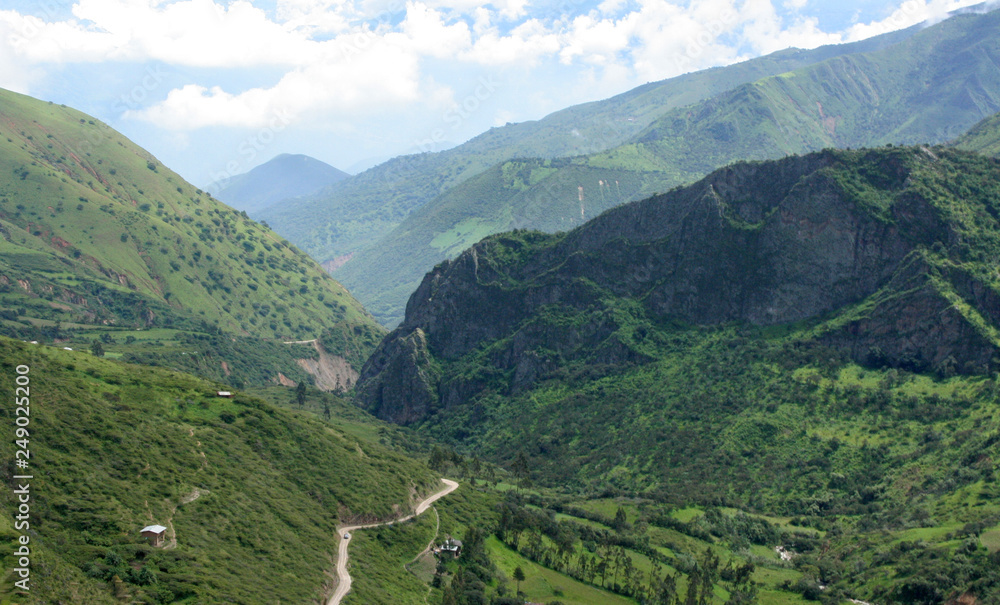 Panorama de valle verde y carretera rural entre las montañas de los andes