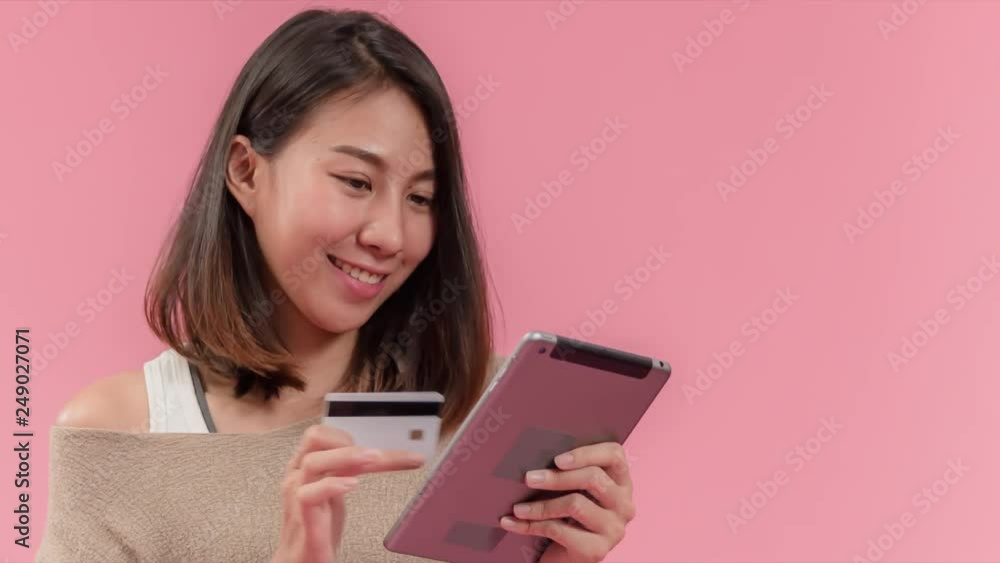 Attractive young asian woman shopping online on web application by using tablet or smartphone, paying by using debit , credit or bank card, Happy life style with modern fin-tech cashless payments. Attractive young asian woman shopping online on web application by using tablet or smartphone, paying by using debit , credit or bank card, Happy life style with modern fin-tech cashless payments.