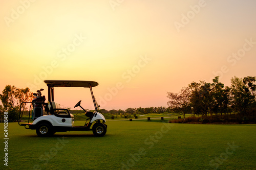 Tableau sur toile Golf cart car in fairway of golf course with fresh green grass field and cloud s