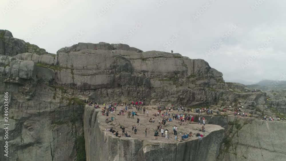 Aerial Breathtaking footage by drone downscending the Pulpit Rock ( Preikestolen) at Lysefjord Norway. People standing on the edge taking  photos. Stock ビデオ | Adobe Stock