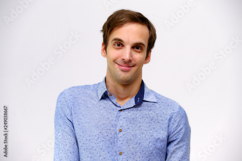 Concept studio portrait of a handsome young man isolated on a white background with different emotions in a blue shirt © Вячеслав Чичаев