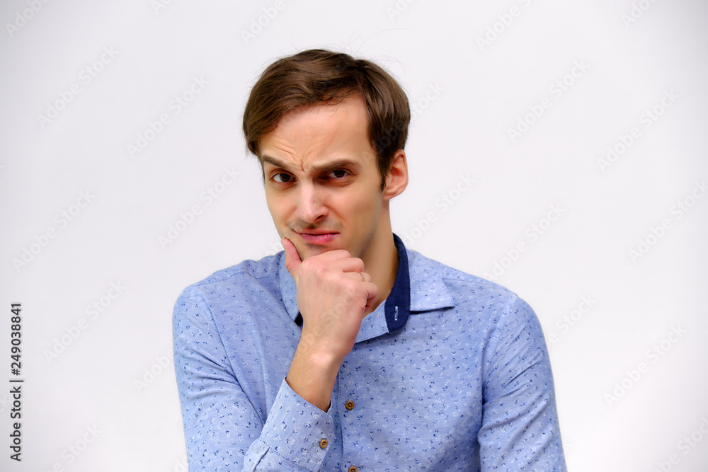 Concept studio portrait of a handsome young man isolated on a white background with different emotions in a blue shirt Concept studio portrait of a handsome young man isolated on a white background with different emotions in a blue shirt