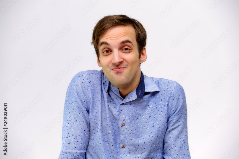 Concept studio portrait of a handsome young man isolated on a white background with different emotions in a blue shirt Concept studio portrait of a handsome young man isolated on a white background with different emotions in a blue shirt