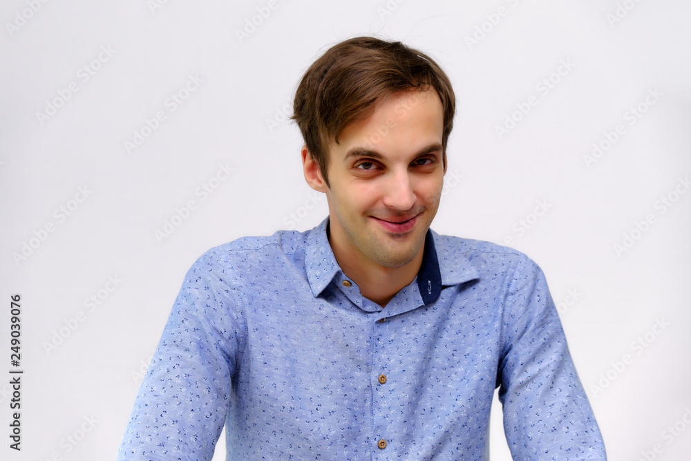 Concept studio portrait of a handsome young man isolated on a white background with different emotions in a blue shirt Concept studio portrait of a handsome young man isolated on a white background with different emotions in a blue shirt