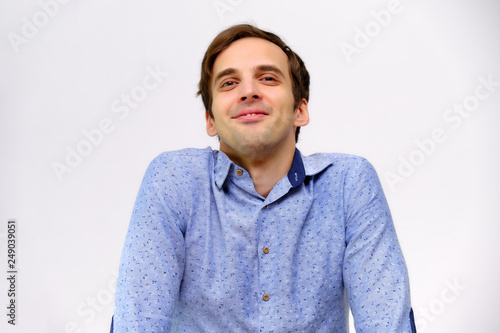 Concept studio portrait of a handsome young man isolated on a white background with different emotions in a blue shirt © Вячеслав Чичаев