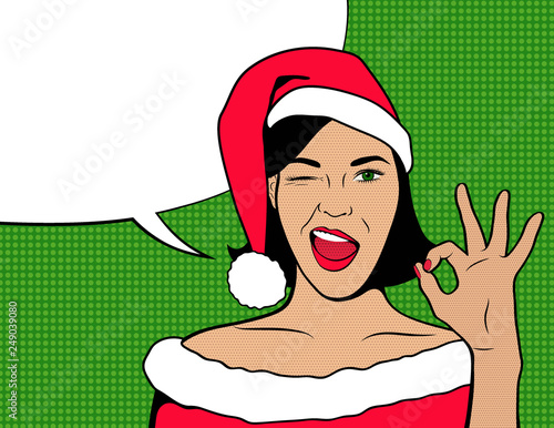 OK pop art New year face. Young sexy woman in Santa hat winking. Bright Vector illustration in retro style of comic books. Merry Christmas party invitation poster. Girl showing OK gesture.